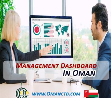 Woman working at a desk with a monitor displaying charts and graphs, illustrating management dashboards in Oman.